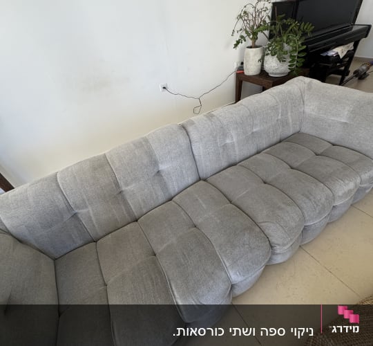ספת בד אפורה נקייה ומטופחת בסלון הבית